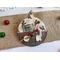 ornament with holly background, includes buttons, cranberry pips, a stamp, mini ticket strip, and a mini ornament tag.